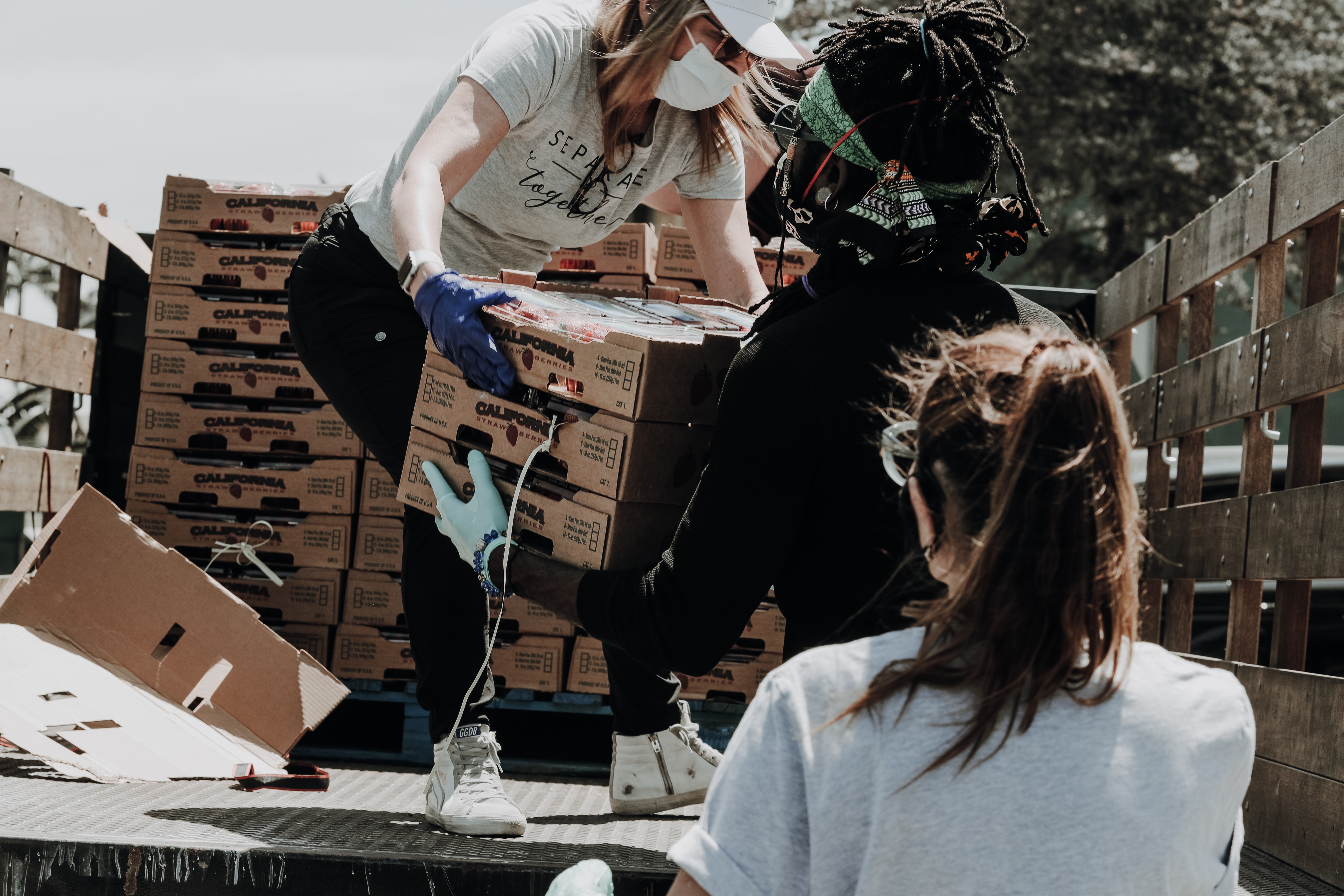 woman-in-back-of-flatbed-truck-handing-out-boxes-of-donations