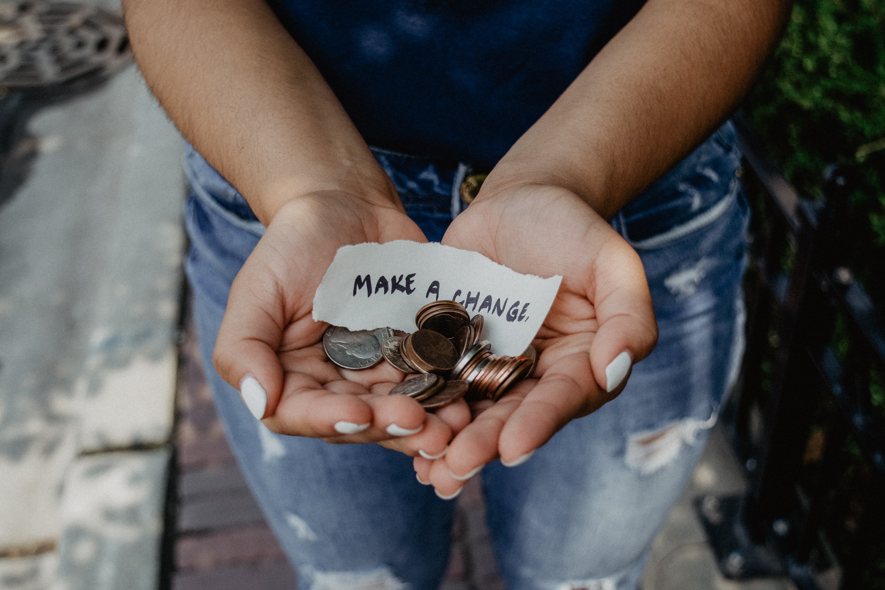 woman-holding-out-hands-with-change-and-make-a-donation-sticker